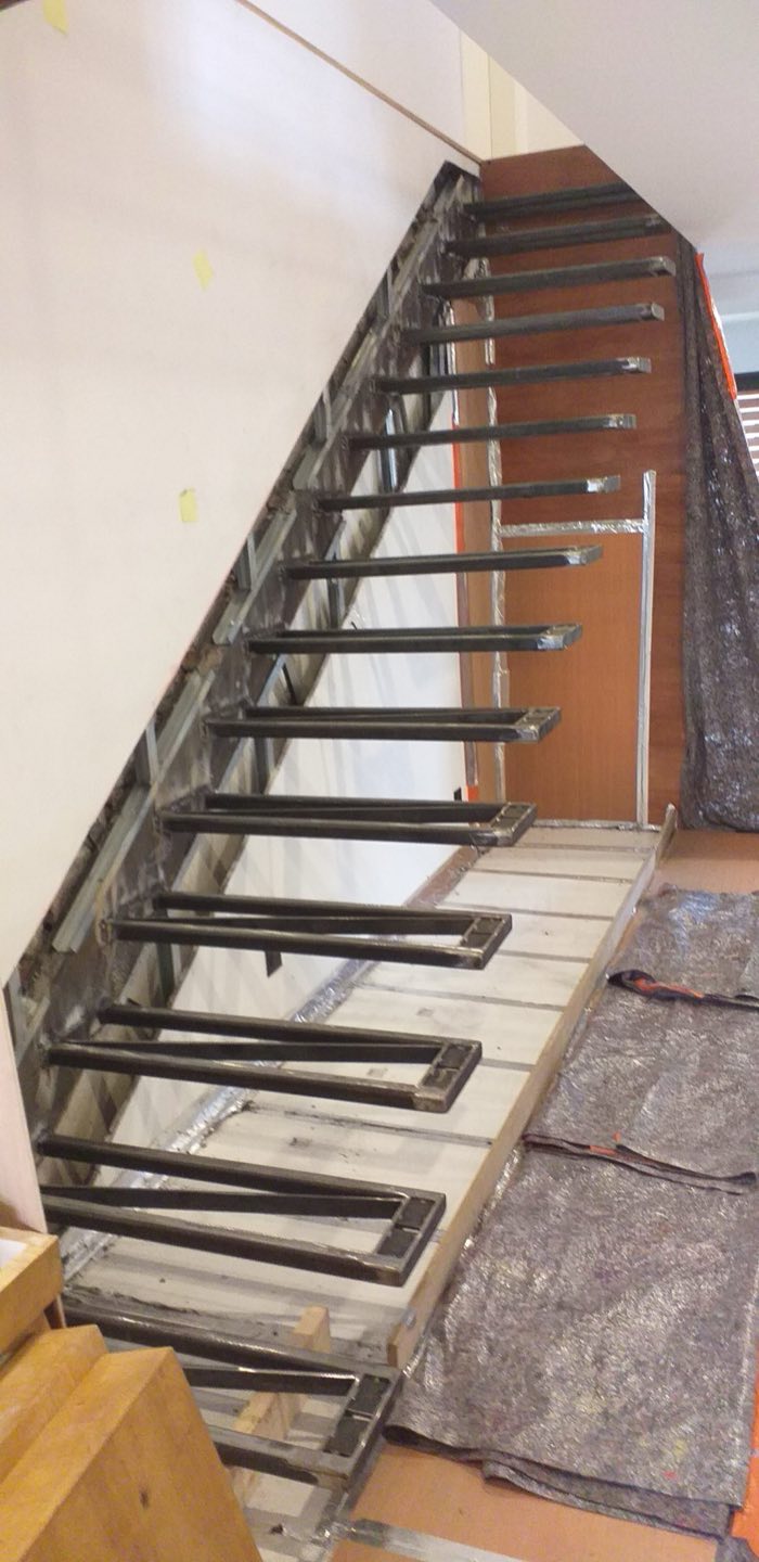 Ossature d'escalier droit en acier brut soudée sur place, marches en attente de leur habillage